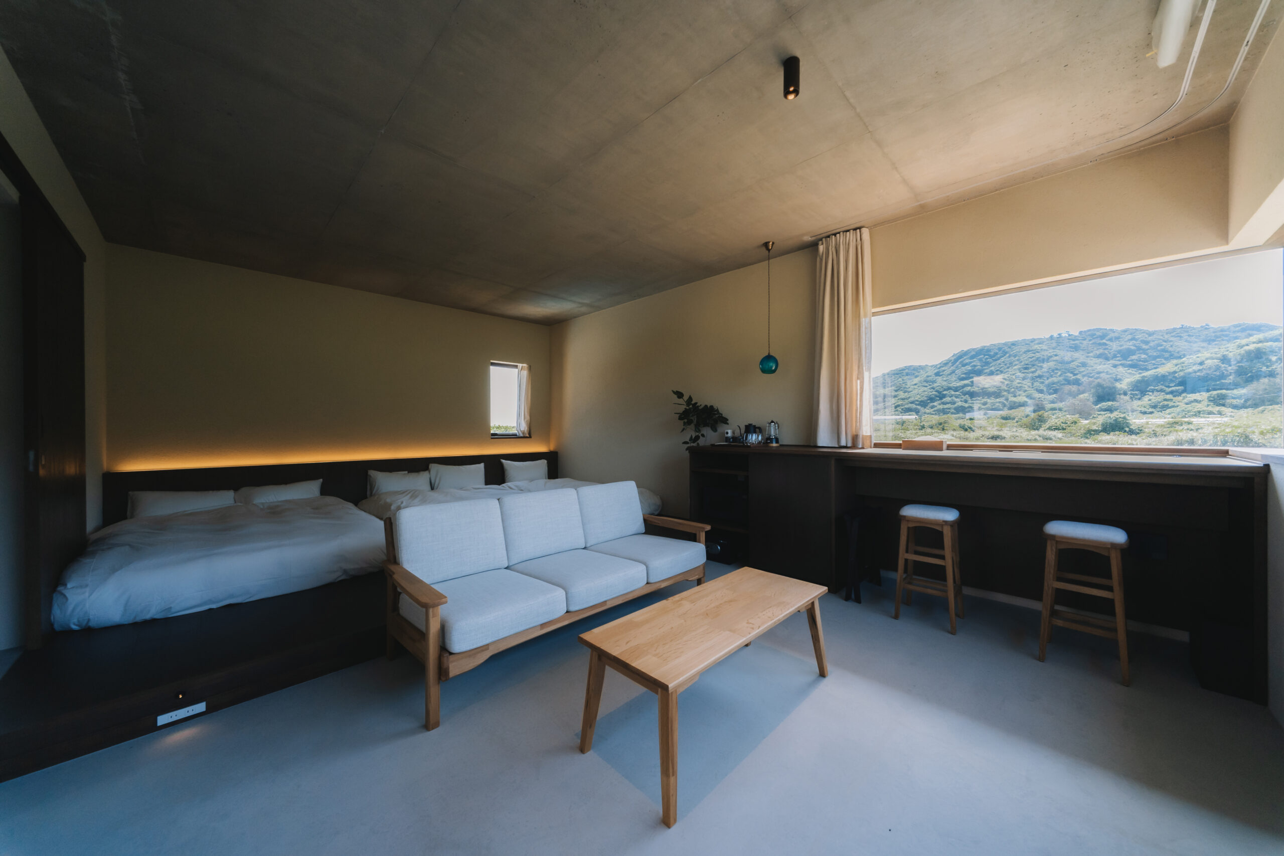 緑を望む大きな窓とソファのあるROOM4